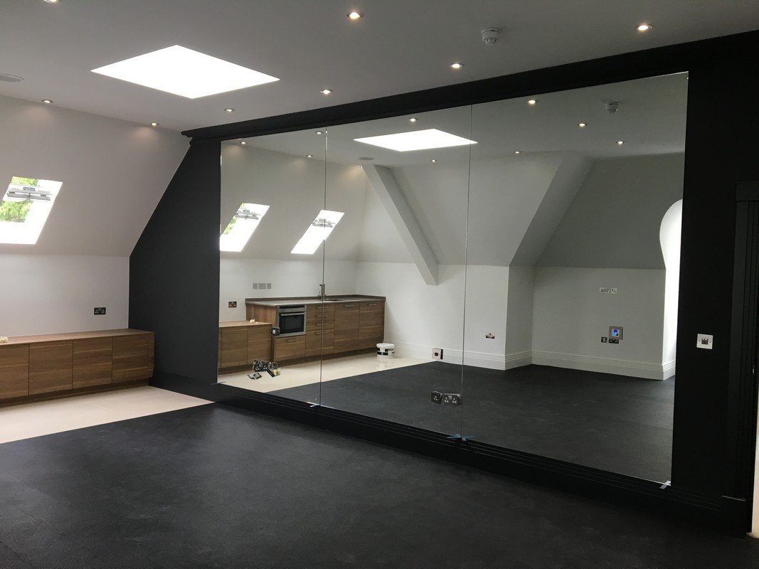 Frameless glass wall dividing loft conversion in Wembley
